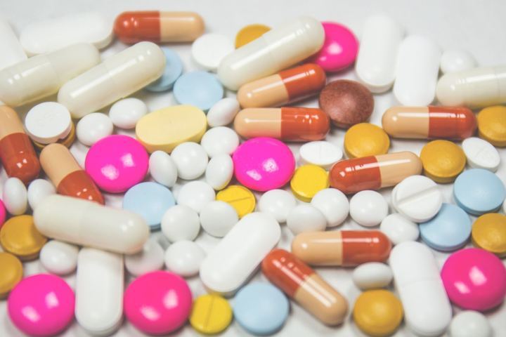 capsule and tablet vitamins supplements spread on a surface top view